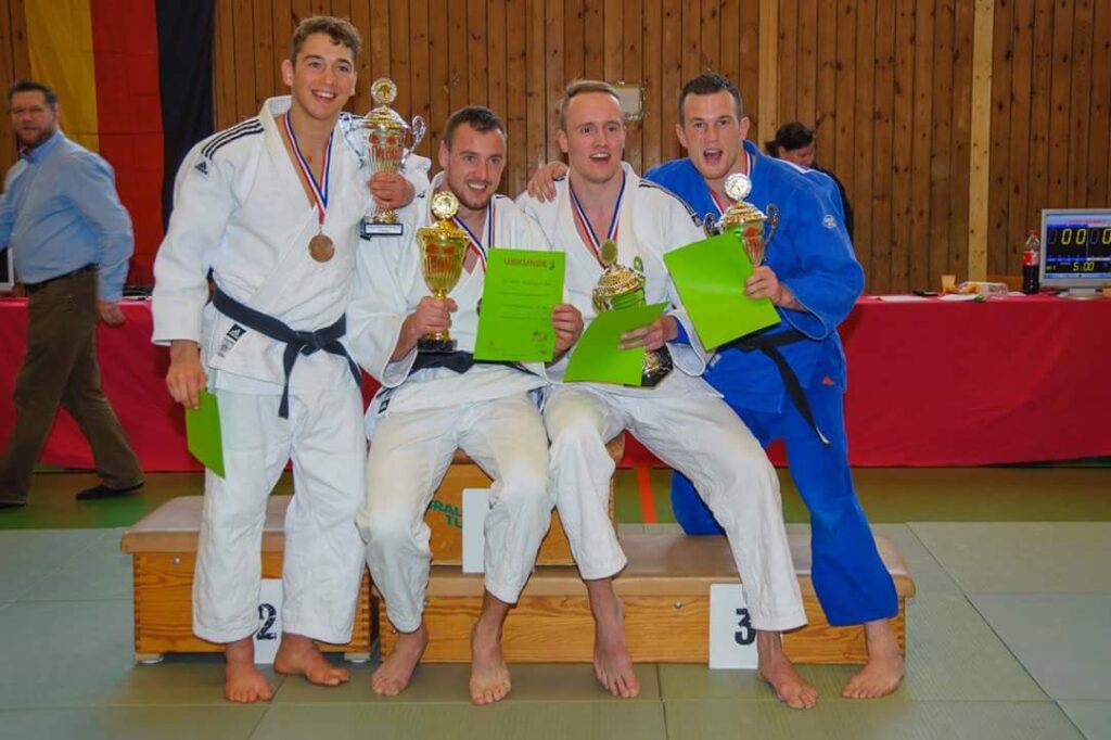 Vier judoka's poseren trots met hun prijzen.