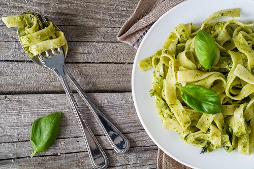 Bord met groene tagliatelle en verse basilicum