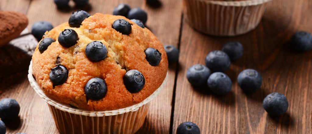 Muffin met blauwe bessen op een houten tafel.