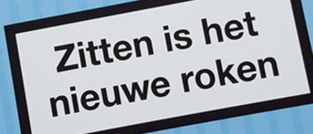 Bord met tekst 'Zitten is het nieuwe roken' op blauwe achtergrond.
