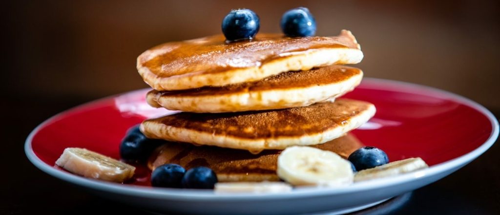 Stapel eiwitpannenkoeken met bosbessen en banaan.
