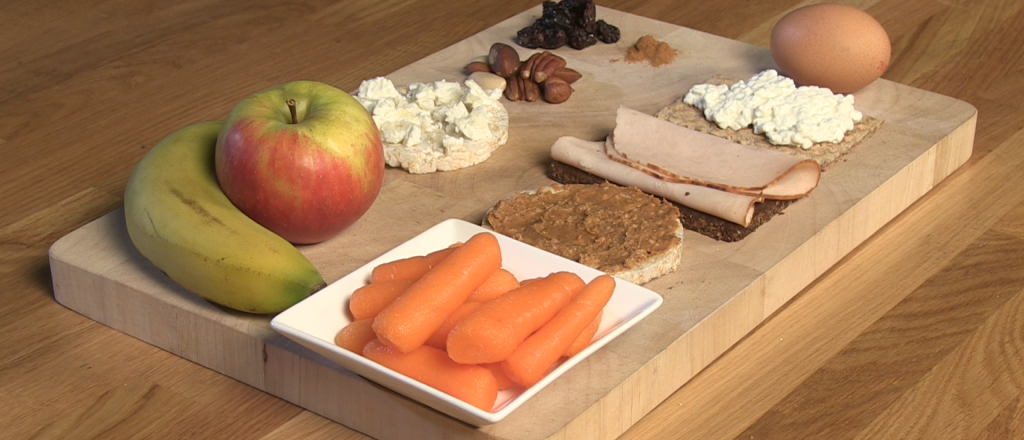 Verschillende gezonde snacks op houten snijplank.