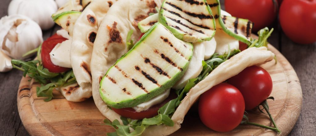 Pita wraps gevuld met hummus, courgette en cherrytomaten.