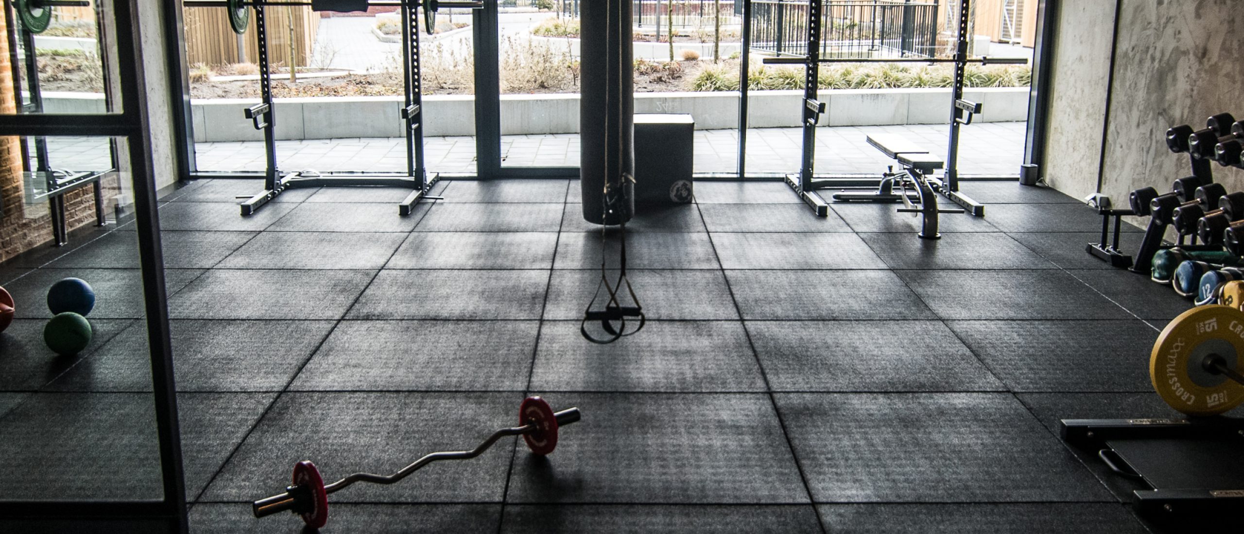 Verschillende vormen van krachttraining, deel 3: hypertrofie 2 Lege fitnessruimte met gewichten en sportapparatuur.