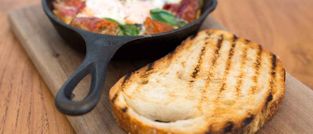 Libanees brood naast skillet met roerei en groenten.