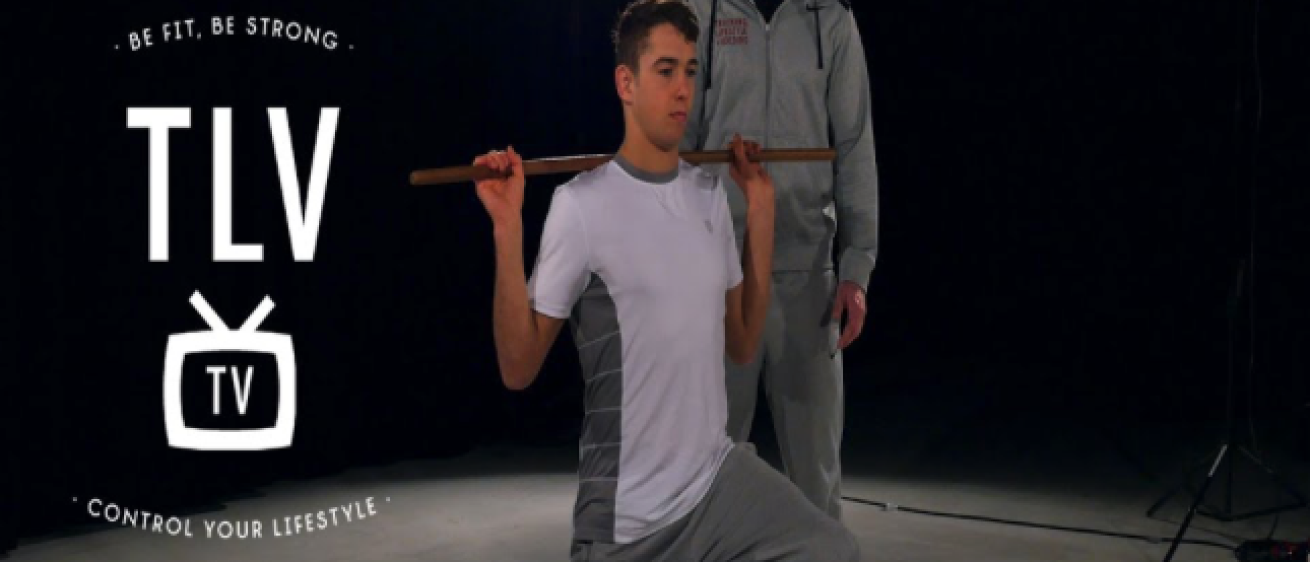 Algemene warming-up met stok voor je training 3 Man doet uitvalpas met stok op schouders
