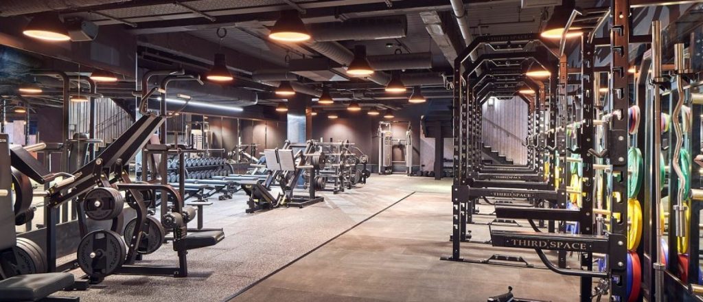 Ruime sportschool met verschillende fitnessapparaten.