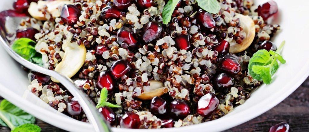 Kom met quinoa, granaatappelpitten en muntblaadjes.