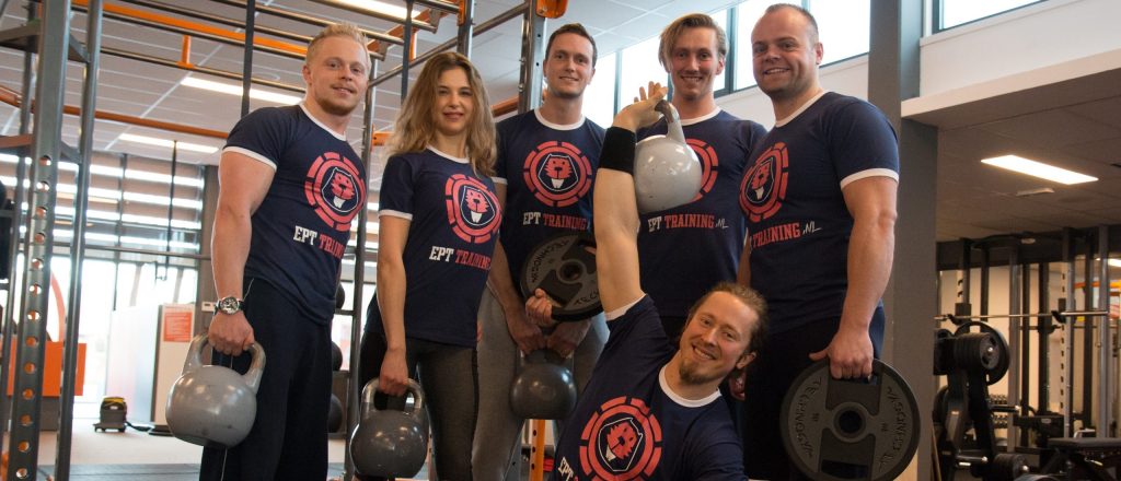 Zes mensen in blauwe EPT Training shirts in sportschool.