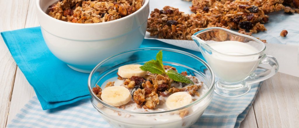 Kom met yoghurt, banaan en speculaasgranola op tafel.