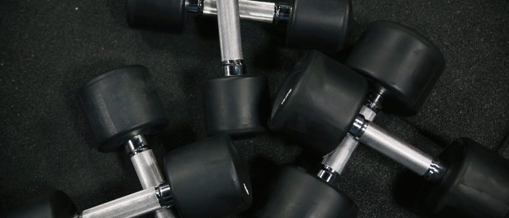 Zwarte halters liggen op een gymvloer.