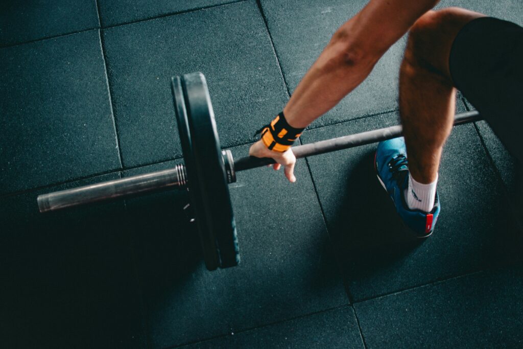 Man bereidt zich voor op een deadlift op de sportschoolvloer.