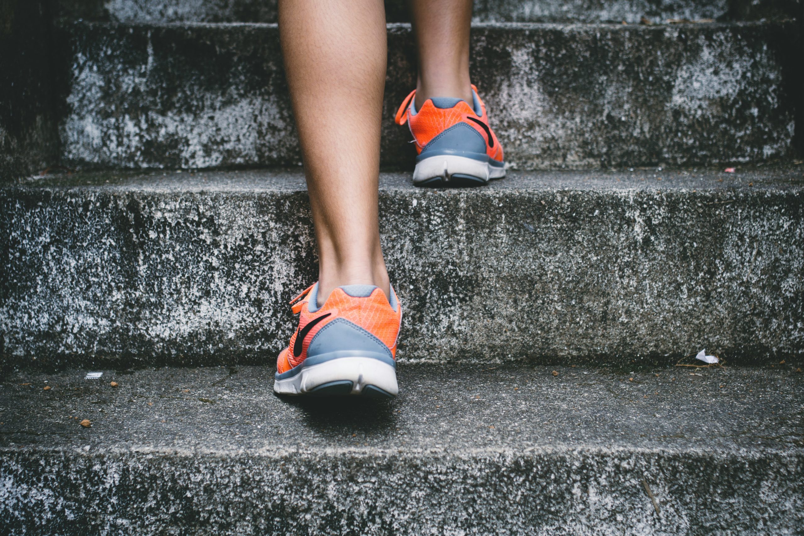 Zero23 trainer's orange sneakers on concrete stairs