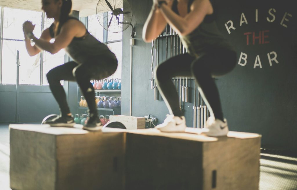 Twee vrouwen doen boxsquats in een sportschool.
