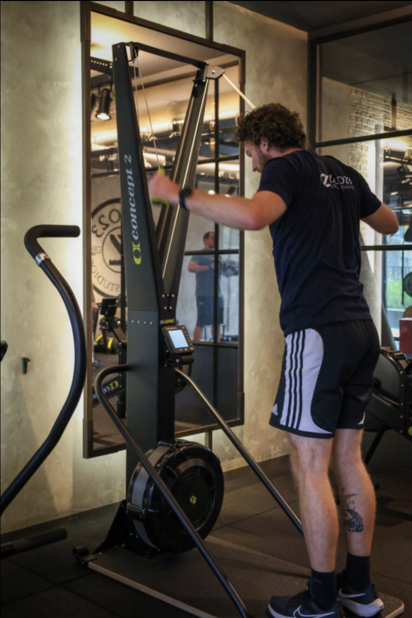 Man traint op een ski-ergometer in de sportschool.