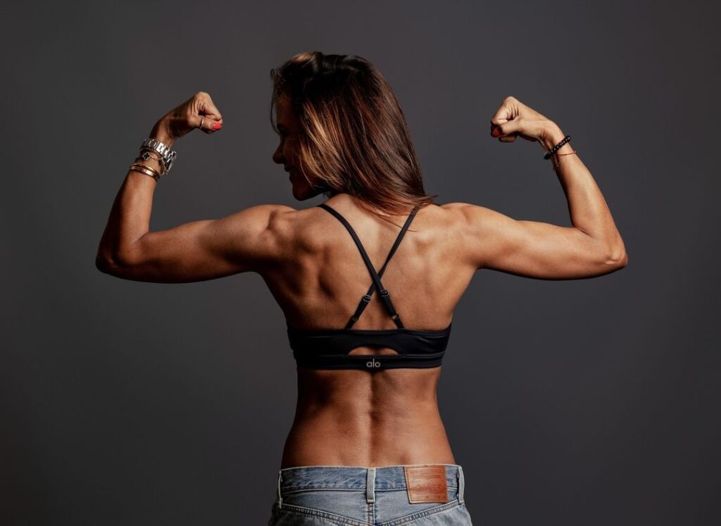 Vrouw in sportkleding toont gespierde armen