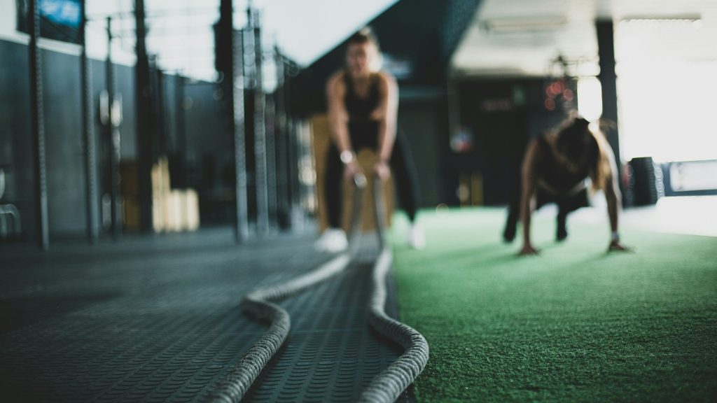 Vrouw doet een oefening met touwen in de sportschool.