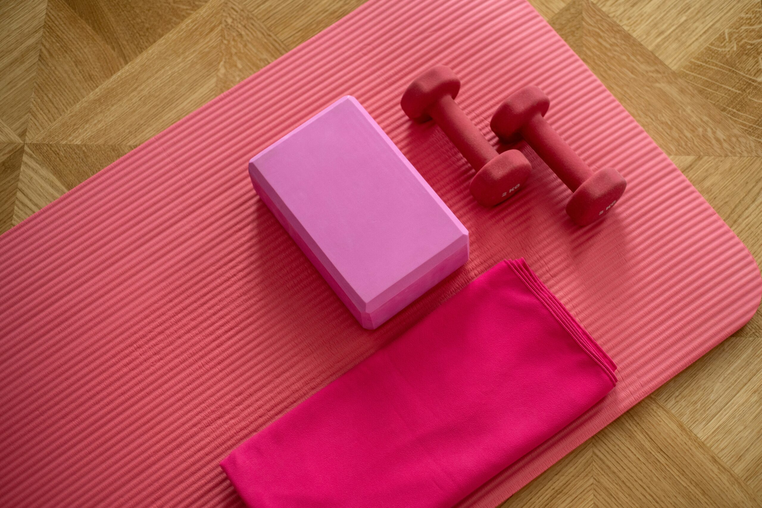 Thuis trainen zonder apparatuur: tips en oefeningen 2 roze yogamat gewichten blok