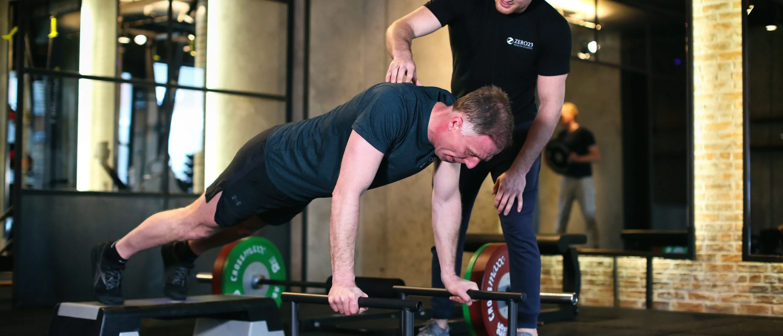 Periodisering 2 Man doet krachttraining met coach in sportschool