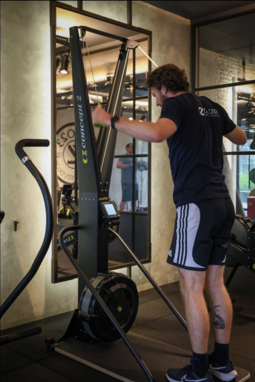 Man traint op een ski-ergometer in de sportschool.