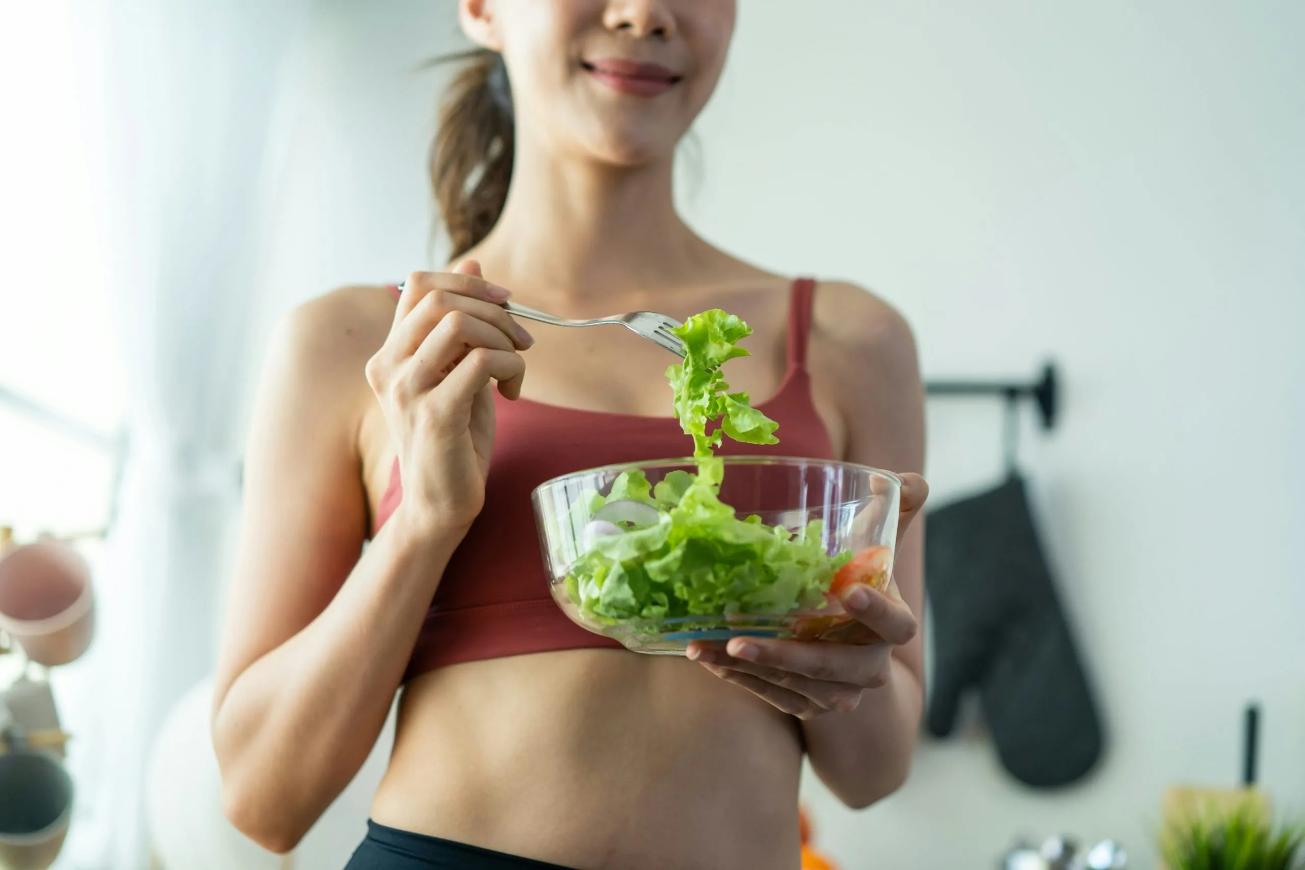 vrouw eet salade sporttop