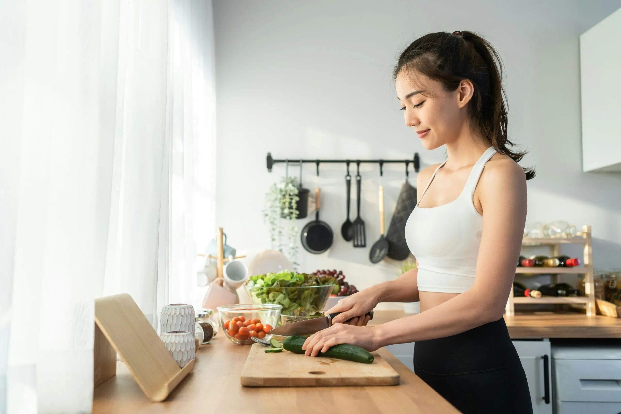 vrouw snijdt komkommer keuken