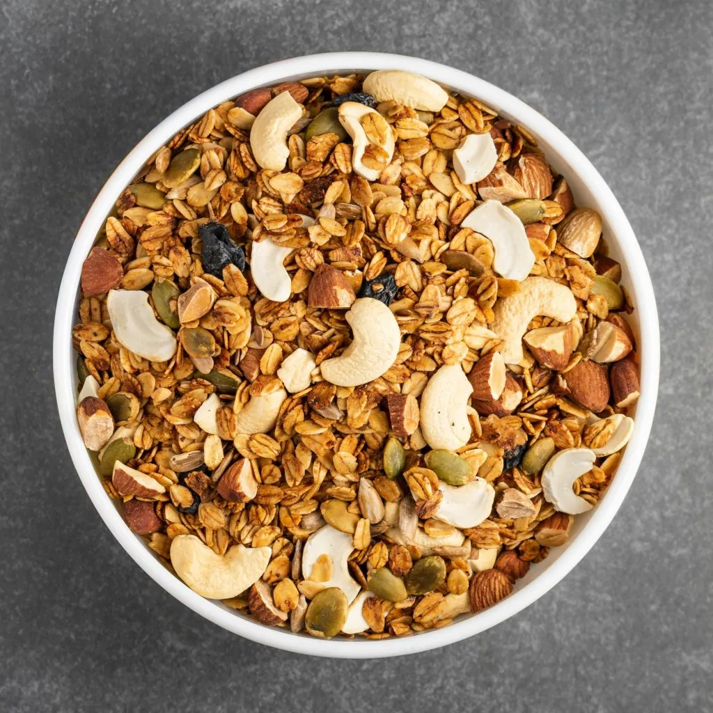 Een kom gevuld met granola en diverse noten.
